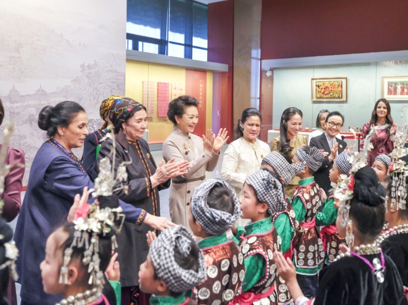 彭丽媛同外方领导人夫人与来自贵州侗族大歌之乡的少年儿童交流。 新华社