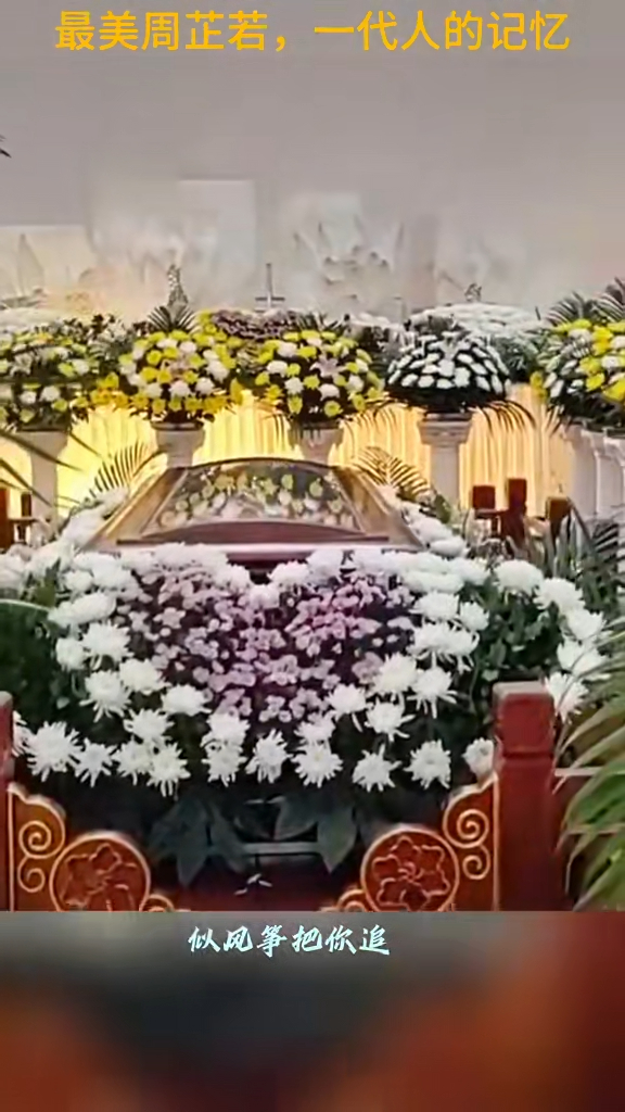 灵堂放置了大量鲜花环绕包围红色棺木。