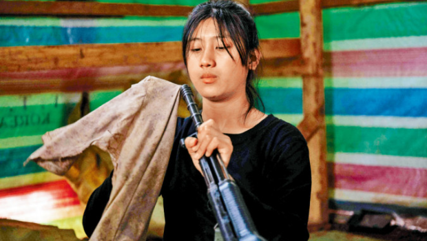 人民防卫军（叛军）一名女兵在缅北掸邦营地擦拭武器。